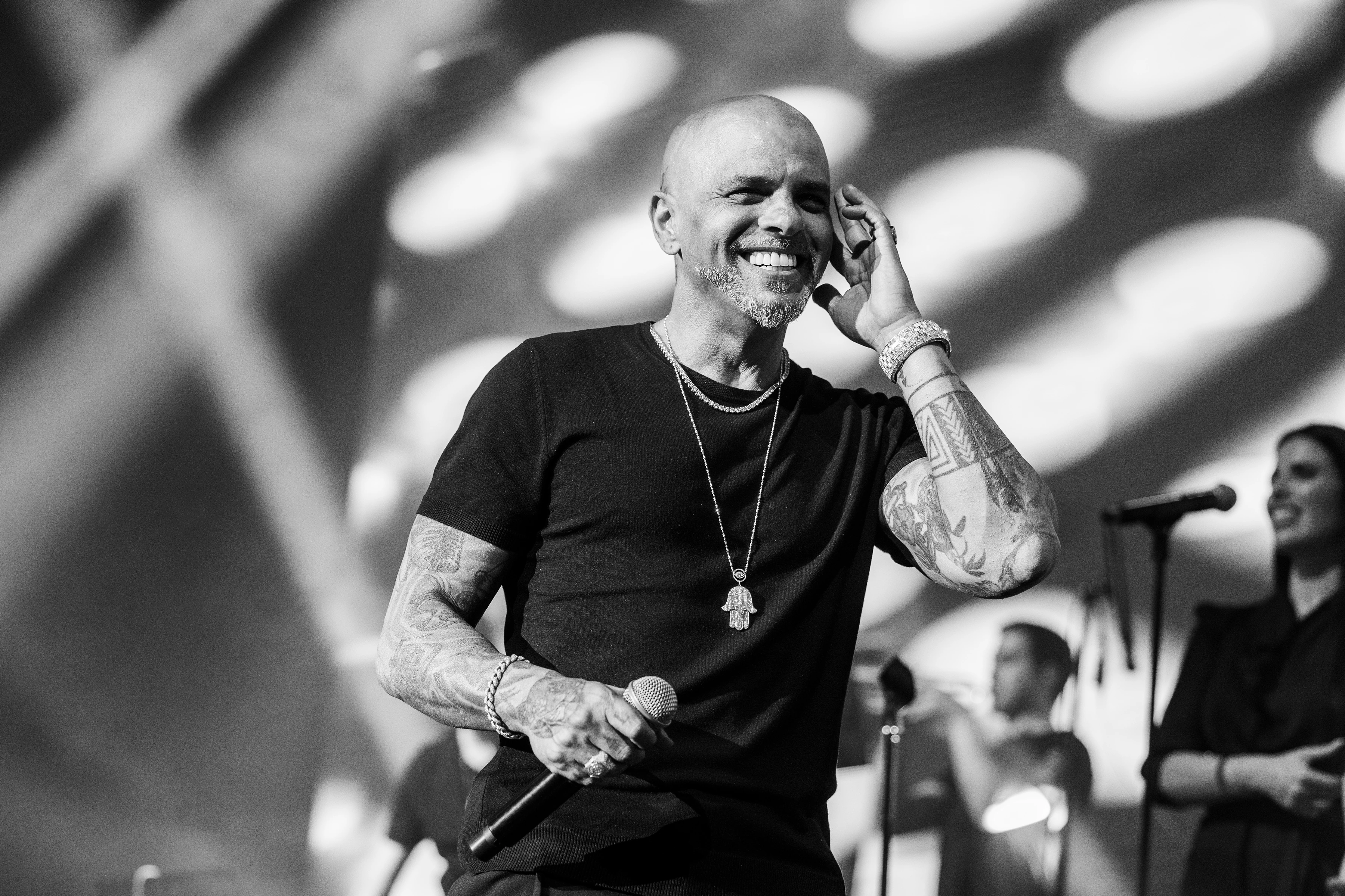Chanteur souriant sur scène, en noir et blanc