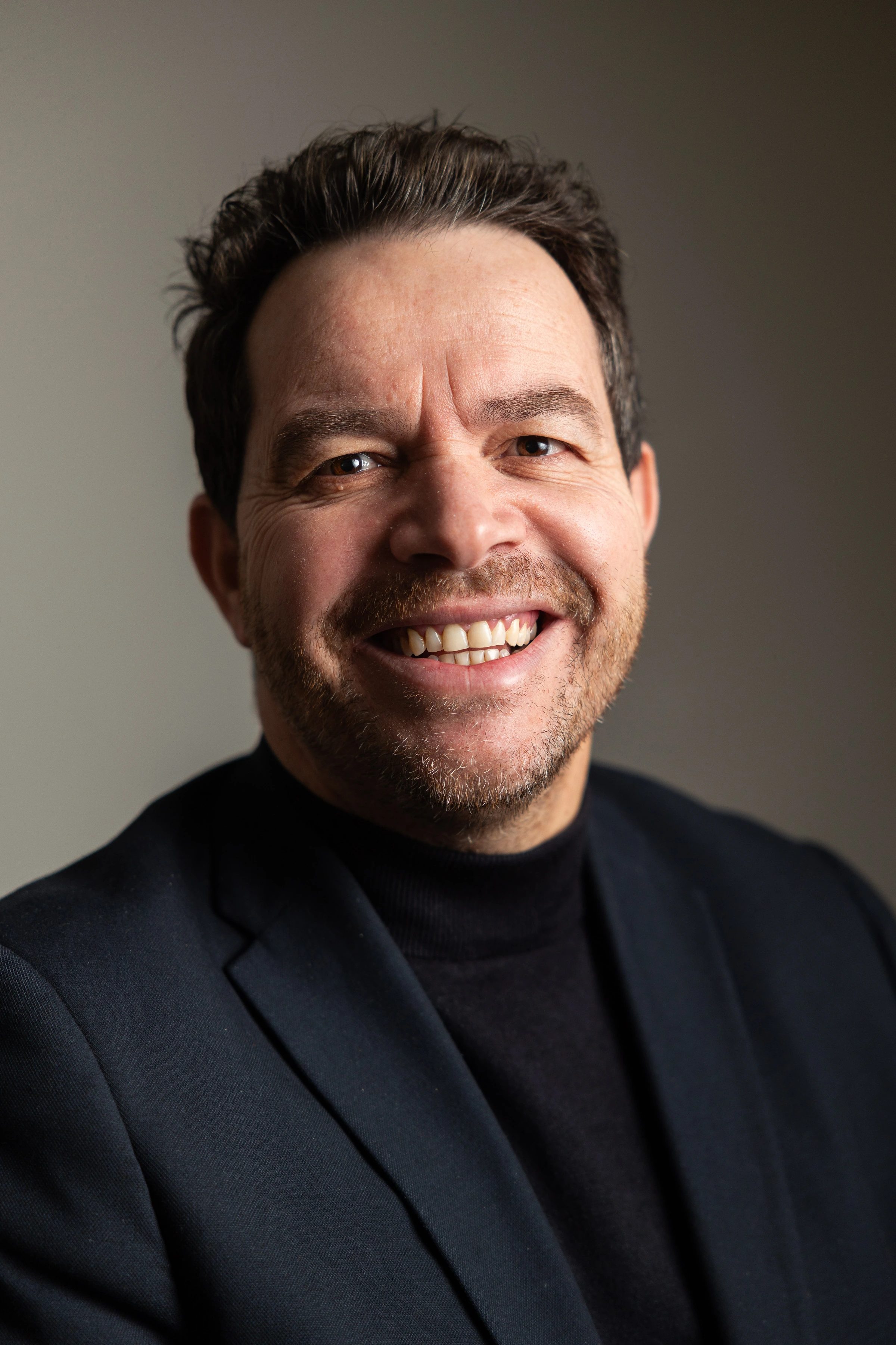 Portrait professionnel d’un dirigeant souriant, en lumière studio